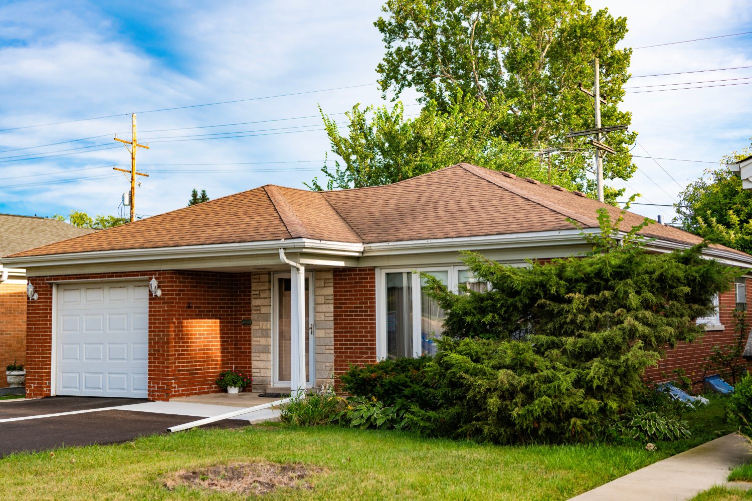 Single-Story Brick Home with Garage and Front Lawn – JP Buys SD Exterior view of a single-story brick house with a garage, front yard, and mature landscaping – JP Buys SD