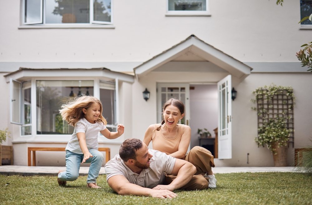 Family Playing in Front Yard – Sell My House Fast Spring Valley CA Joyful family enjoying time together on the lawn outside their home, representing a successful quick home sale – Sell My House Fast Spring Valley CA