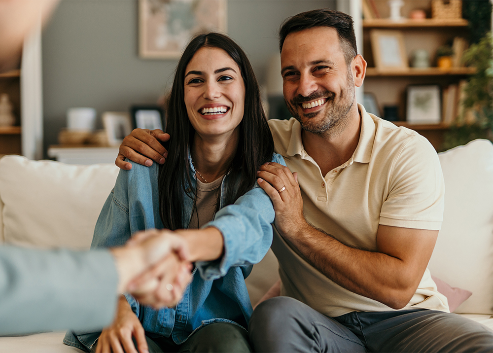 Happy Couple Closing Home Sale – Sell My House Fast Spring Valley CA Smiling couple shaking hands with a real estate professional after a successful home sale – Sell My House Fast Spring Valley CA